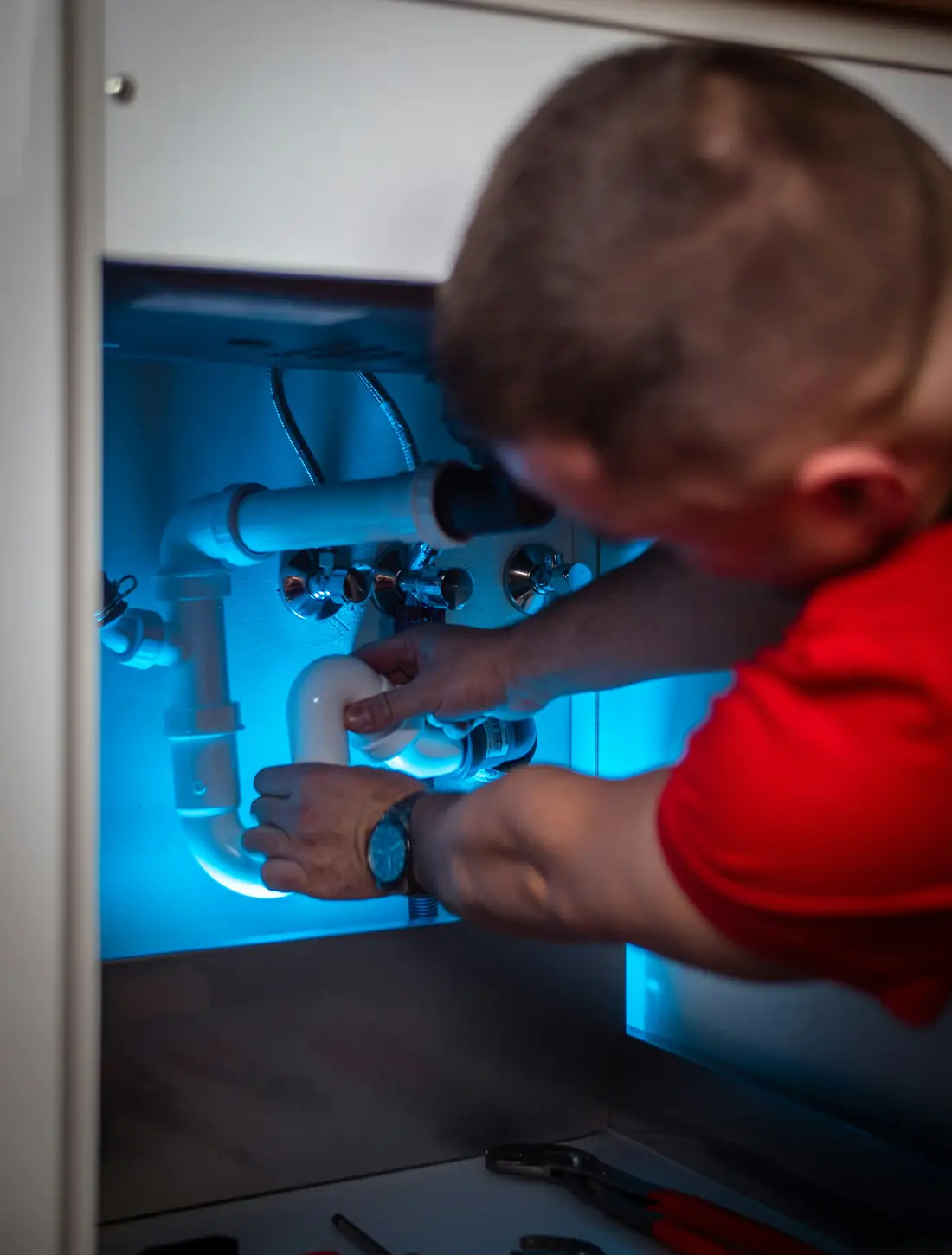 A technician working under a sink